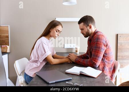 Nahansicht der verärgert zuversichtlich Frau und junge unrasiert Mann mit ernsthaften Gespräch in hell beleuchteten Schlafzimmer, versuchen, sich gegenseitig zu unterstützen, Familie con Stockfoto