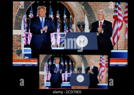 Washington, USA. August 2020. Das Foto, das am 26. August 2020 in Arlington, Virginia, USA, aufgenommen wurde, zeigt Bildschirme, auf denen US-Vizepräsident Mike Pence (R) auf der Bühne von US-Präsident Donald Trump nach seiner Rede während der Republikanischen Nationalkonvent von Fort McHenry in Baltimore, Maryland, 2020, begleitet wurde. US-Vizepräsident Mike Pence nahm am Mittwochabend die Nominierung der Republikanischen Partei für eine zweite Amtszeit in einer Rede von Fort McHenry in Baltimore, Maryland, an. Quelle: Liu Jie/Xinhua/Alamy Live News Stockfoto