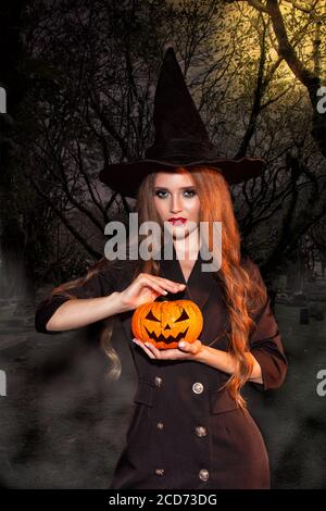 Hexe Frau im Halloween Kostüm mit langen lockigen Haaren und Perfektes Make-up Stockfoto