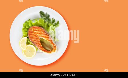 Gegrilltes Lachssteak mit Zitrone und Salat. Draufsicht flach liegend mit Kopierplatz Stockfoto