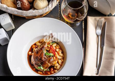 Ente Confit Bein mit weißen Bohnen garnieren Stockfoto