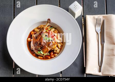Ente Confit Bein mit weißen Bohnen garnieren Stockfoto