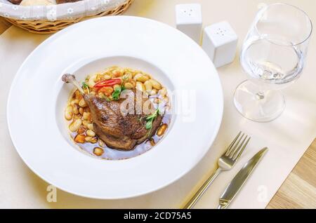 Ente Confit Bein mit weißen Bohnen garnieren Stockfoto