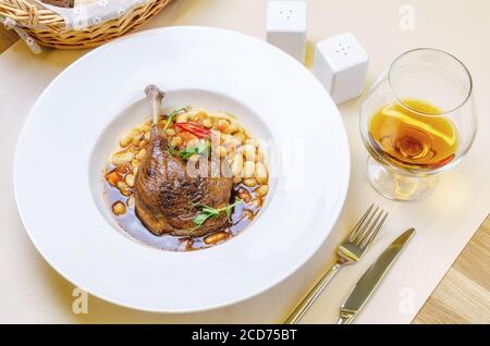 Ente Confit Bein mit weißen Bohnen garnieren Stockfoto