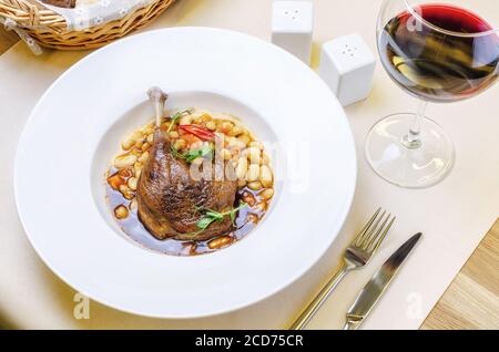 Ente Confit Bein mit weißen Bohnen garnieren Stockfoto