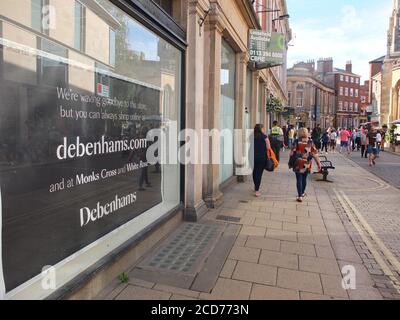 Die Käufer passieren ein Schild im Fenster des mit Schwierigkeiten kämpfenden Kaufhauses der britischen Kette Debenhams auf Davygate in York, das besagt, dass die Filiale geschlossen wurde. Stockfoto