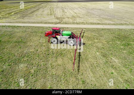 Traktor mit hoher Freiraum für die Bewässerung von Pflanzen auf dem Feld. Stockfoto