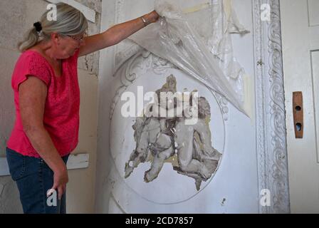 Heinersdorf, Deutschland. August 2020. Gabriele Breitenstein, wohnhaft in Heinersdorf, zeigt ein historisches Gemälde im Herrenhaus Heinersdorf im Landkreis oder-Spree. Brandenburg ist reich gesegnet mit alten Villen und Schlössern. Wo finanziell starke neue Besitzer und Nutzer gefunden werden, blühen die Denkmäler neu. Gehören sie jedoch zu Gemeinden, sind sie damit in der Regel überfordert. In Heinersdorf kämpfen die Bürger seit Jahren um die Rettung "ihres" Herrenhauses. Quelle: Patrick Pleul/dpa-Zentralbild/ZB/dpa/Alamy Live News Stockfoto