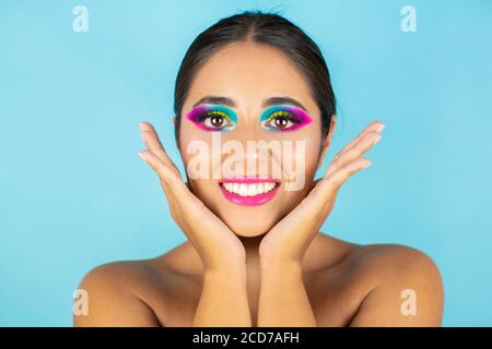 Schönheit Porträt von weiblichen Modell lächelnd mit lebendigen Make-up auf blauem Hintergrund. Stockfoto