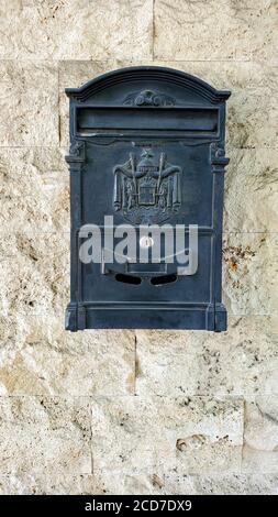 Vintage Briefkasten mit antikem Emblem Prägung Nahaufnahme auf Rohstein Wandhintergrund mit Kopierplatz Stockfoto