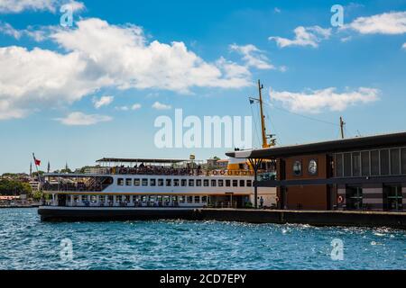 Ein Fährschiff mit türkischer Flagge, das an einem Pier festgemacht ist und an einem bewölkten Sommertag auf seine Passagiere wartet, Istanbul, Türkei Stockfoto