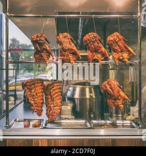 Geröstete Enten und Rippen hängen an der Schauablage im Restaurant's Küche Stockfoto