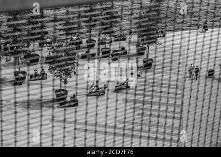 Schwarz-Weiß-Aufnahme des Karakoy-Piers, Menschen, die während der Pandemie-Zeit von Covid-19 auf Bänken herumlaufen und sitzen, Istanbul, Türkei. Stockfoto