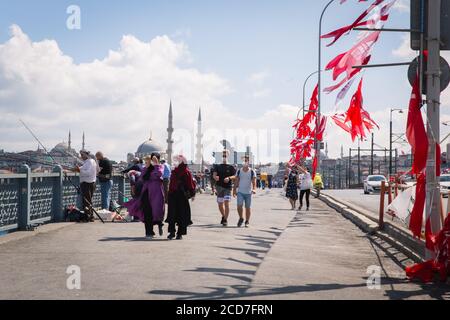 ISTANBUL / TÜRKEI - 07.17.2020: Menschen fischen und wandern auf der Golden Horn (Halic) Brücke, die Yeni Moschee im Hintergrund, Eminonu. Stockfoto