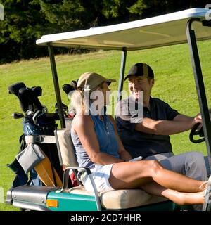 Mann und Frau Golf spielen auf einem schönen Parklandschaft an einem sonnigen Tag im Sommer. Stockfoto