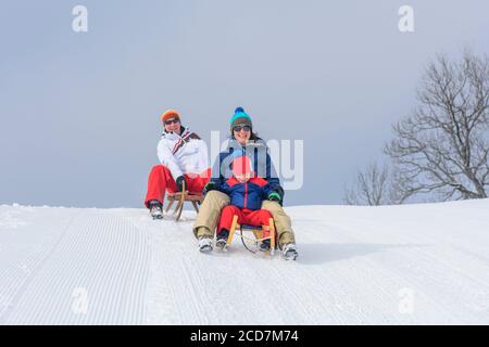 Die Familie hat Spaß im frischen Schnee an einem winterlichen Tag Stockfoto