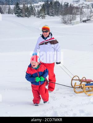 Die Familie hat Spaß im frischen Schnee an einem winterlichen Tag Stockfoto