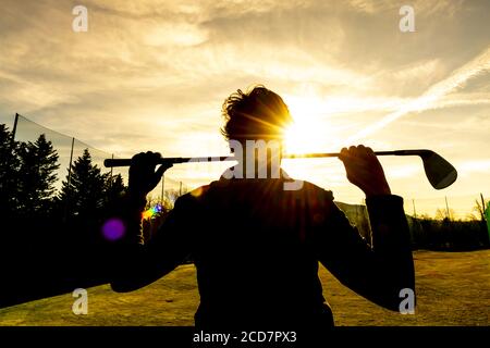 Golfer Leaning ihren Golfclub auf ihren Schultern mit Sonnenlicht. Stockfoto