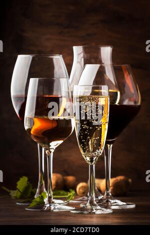 Weinverkostungskonzept, Stillweine und Schaumweine. Rot, Weißwein, Rose und Champagner in Weingläsern auf Vintage Holztisch Hintergrund Stockfoto