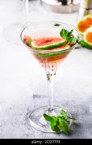 Pink Fig martini Cocktail aus Schnapsglas auf grauem Tisch mit Bar-Tools, selektiver Fokus Stockfoto