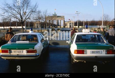 Bildbericht: Berlin kurz nach dem Fall der Mauer, hier zwei westdeutsche Streifenwagen der Polizei vor dem Brandenburger Tor, Deutschland, Dezember 1989. Stockfoto