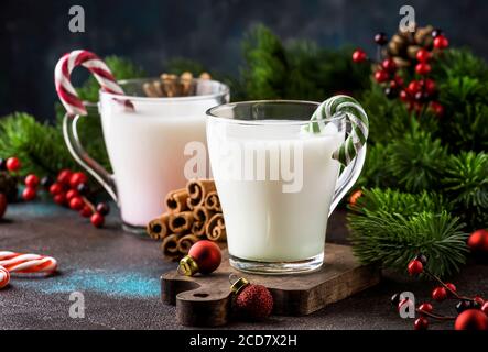 Heißer Winter-Weißgetränk mit Candy Sticks, Weihnachten oder Neujahr Dekorationen, dunkler Hintergrund, rustikalen Stil, Kopierraum Stockfoto