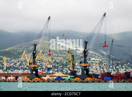 Novorossijsk, Russland - 24. Juni 2017: Blick auf den kommerziellen Seehafen, Schiffe auf Verladung und Hafenkrane an einem stürmischen Sommertag Stockfoto