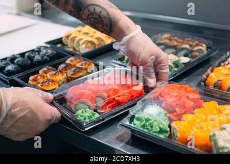 Sushi-Lieferung. Viele Sorten Sushi in einer Plastikbox sind für die Lieferung vorbereitet. Stockfoto