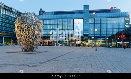 Nachtansicht des Einkaufszentrums Kamppi im Zentrum von Helsinki, Finnland. Das 2006 eröffnete Gebäude beherbergt den zentralen Busbahnhof und die U-Bahn-Station Stockfoto