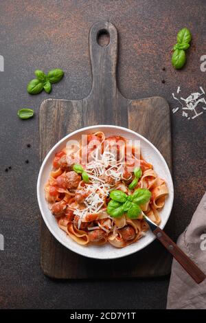 Italienische hausgemachte Pasta Fettuccine mit Fleischbällchen, Parmesan, Basilikum. Blick von oben. Stockfoto