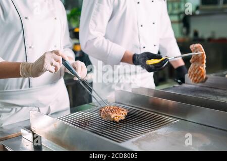 Kocht Braten Fleisch auf dem Herd in der Küche eines Restaurants oder Hotels. Stockfoto