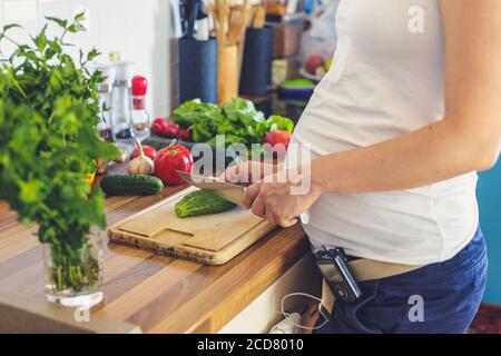 Schwangere Frau mit insuline Pumpe Vorbereitung gesunde Lebensmittel in der Küche Stockfoto