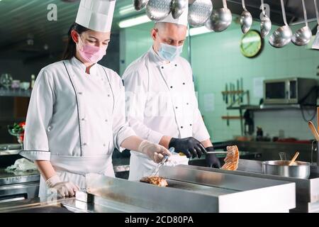 Kocht Braten Fleisch auf dem Herd in der Küche eines Restaurants oder Hotels. Stockfoto