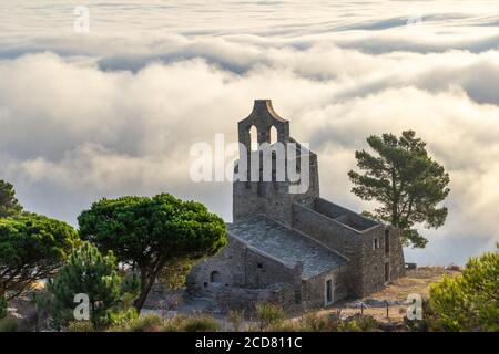 Santa Helena Kapelle in den Wolken in der Serra de Rodes in der Nähe des Benediktinerklosters Sant Pere de Rodes, Costa Brava, Katalonien Stockfoto