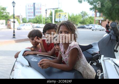 jodhpur, rajasthan, indien, 20. September 2020: indische arme Obdachlose kleine Kinder tragen schmutzige Kleidung Blick auf die Kamera, Straßenrand Hintergrund outs Stockfoto