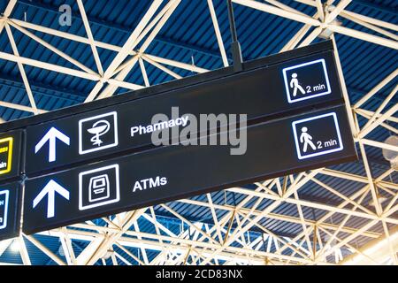 Anfahrt auf dem Schild am Flughafen - Apotheke und GELDAUTOMAT Stockfoto