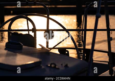 Nahaufnahme des Segelbootes mit Sonnenuntergang, der vom Wasser reflektiert wird Hintergrund Stockfoto