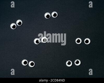 Sechs Paar schöne Augen auf schwarzem Hintergrund. Ansicht von oben oder flach liegend. Plastikspielzeug Augen auf dunklem oder balckem Hintergrund - halloween-Konzept Stockfoto