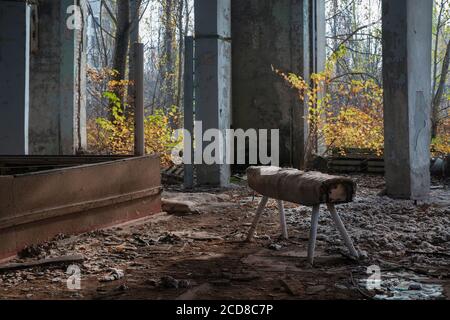 Verlassene Räumlichkeiten in der Schule Nr. 5 in der Stadt Pripyat, in der Mitte des Raumes ist ein Sportgerät zum Springen, Tschernobyl Ausschlusszone 20 Stockfoto