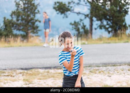 Zwei Mädchen haben Spaß mit den Walkie-Talkies auf dem Berg Stockfoto