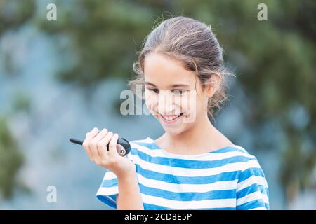 Nahaufnahme eines lächelnden Mädchens mit einem Walkie-Talkie im Freien Stockfoto
