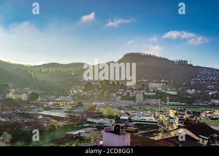 Stadtansicht mit Berg und hellblauen Himmel von der Hügelspitze bei Sonnenaufgang Bild wird von doddabetta Gipfel ooty indien genommen. Es zeigt die Vogelperspektive von o Stockfoto