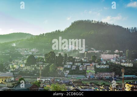 Stadtansicht mit Berg und hellblauen Himmel von der Hügelspitze bei Sonnenaufgang Bild wird von doddabetta Gipfel ooty indien genommen. Es zeigt die Vogelperspektive von o Stockfoto