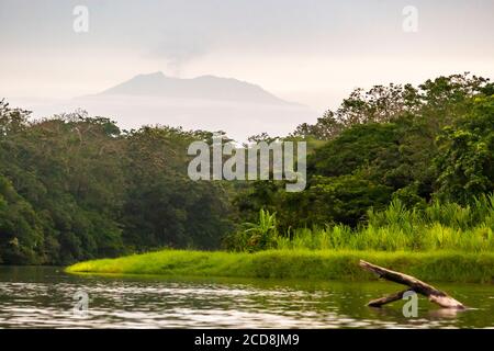 Vulkan am Horizont hinter einem Kanal bei Pacuare am Atlantischen Ozean bei Reventazón, Costa Rica Stockfoto