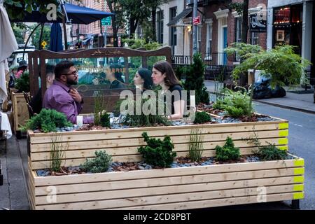 Sitzplätze im Freien während der Pandemie von Covid 19 im Petit Boucherie Bistro mit schützenden Plexiglas-Bildschirmen in Greenwich Village, New York City, NY, USA Stockfoto