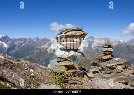 Turm gefaltet von einem Mann aus Bergsteinen gegen ein Hintergrund einer Berglandschaft Stockfoto