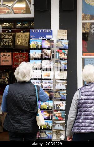 Ein Postkartenständer, der vor einem Geschäft von einem älteren Touristen, York, North Yorkshire, England, Großbritannien, gesehen wird. Stockfoto