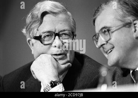 Sir Geoffrey Howe – stellvertretender Ministerpräsident und Lord President of the Council – spricht mit Kenneth Baker – dem Kanzler des Herzogtums Lancaster. Konservative und unionistische Parteikonferenz im Bournemouth International Centre in Dorset. Oktober 1990. Foto: Neil Turner Stockfoto