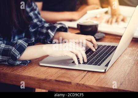 Geschäftsfrau sitzt am Schreibtisch und tippen auf einem Laptop Hände aus der Nähe, anonymes Gesicht Stockfoto