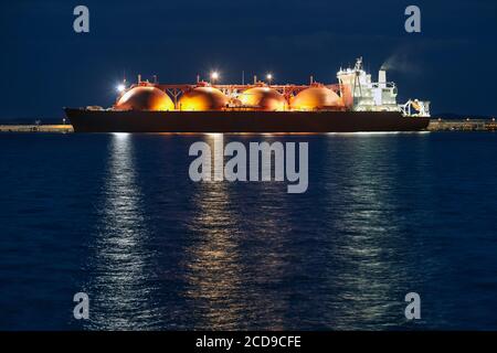 Bild eines LNG-Tankers im Hafen bei Nacht. Stockfoto